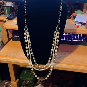 Long layered pearl necklace with matching earrings.